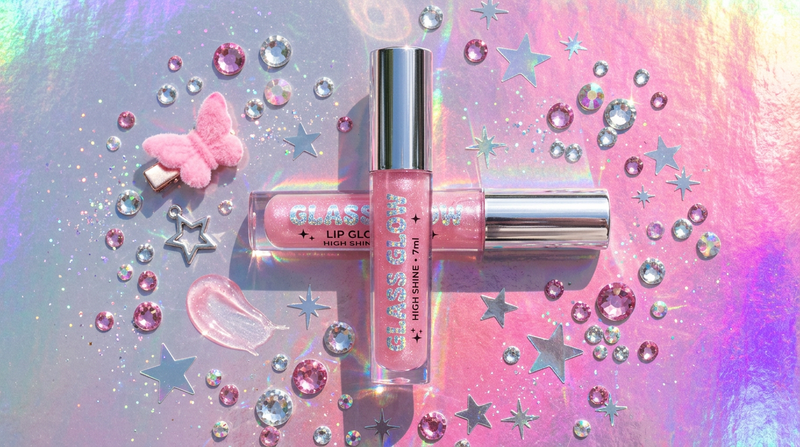 Glass Glow Lip Glaze flat lay on holographic silver pink gradient background with crystal rhinestones and Y2K star stickers