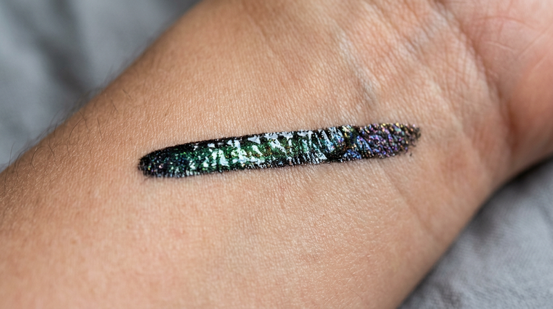 Close-up macro of multichrome gel eyeliner swatch on skin showing prismatic color-shifting finish