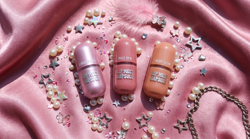 Three Luminous Lip Melt capsule shades Lunar Petal Rose Dew Nude Glow on pink satin with pearl beads and star charms - Y2K beauty flat lay