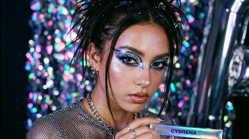 Y2K dramatic editorial eye look with color-shifting liner, prismatic holographic bokeh, Cybrena brand