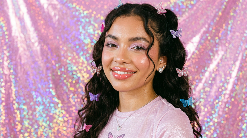 Model with plump luminous hydrated lips Y2K inspired beauty look with rhinestone earrings and butterfly hair accessories