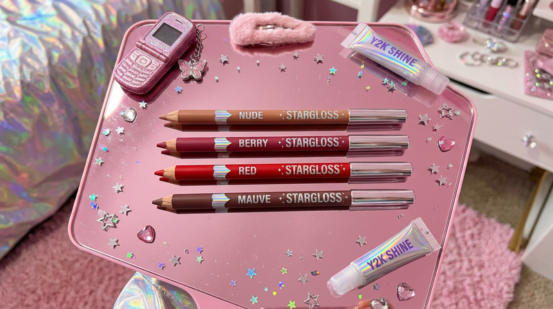 Four lip liner pencils in nude berry red brown mauve on pink mirror surface with Y2K holographic foil accents and star charms